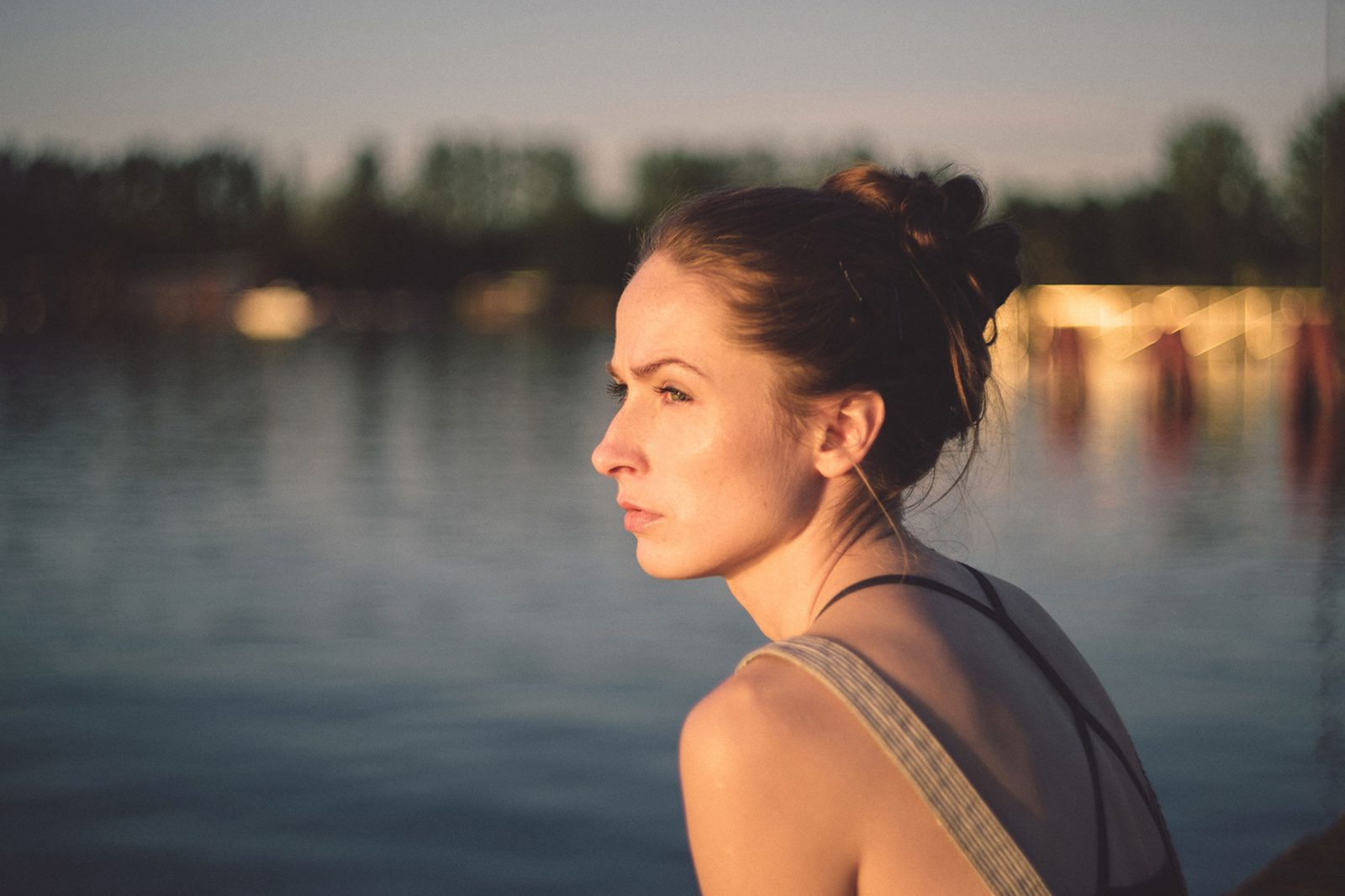 A woman sat looking out over a lake
